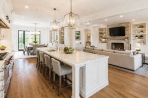 Bright modern open kitchen with marble island and connected living area.
